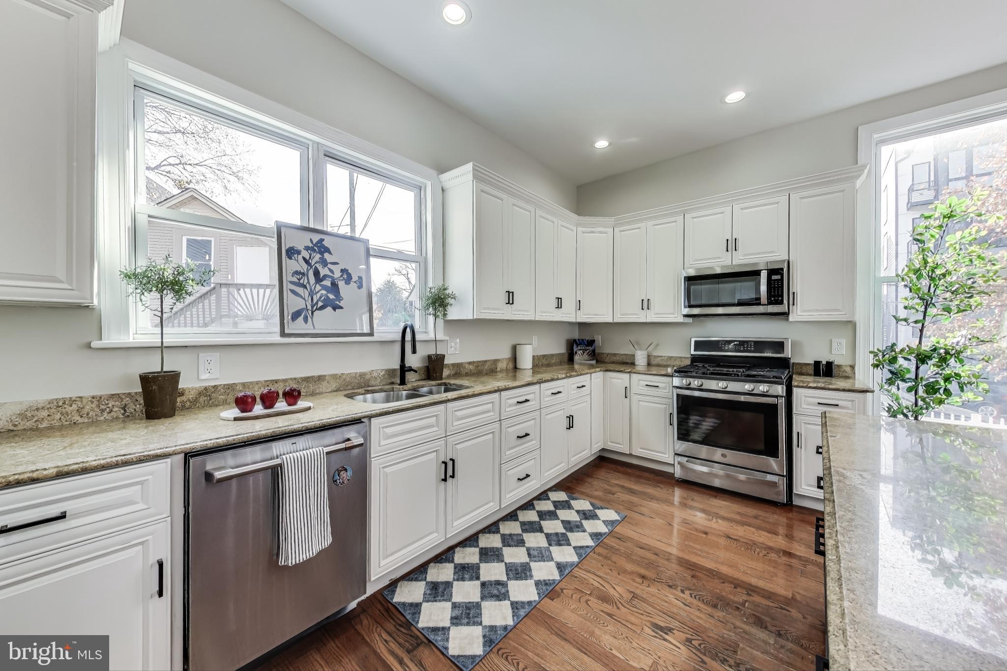 4301 Kansas Avenue Northwest Washington, DC 20011 - Photo 21 of 80 a kitchen with granite countertop a stove a sink and a microwave