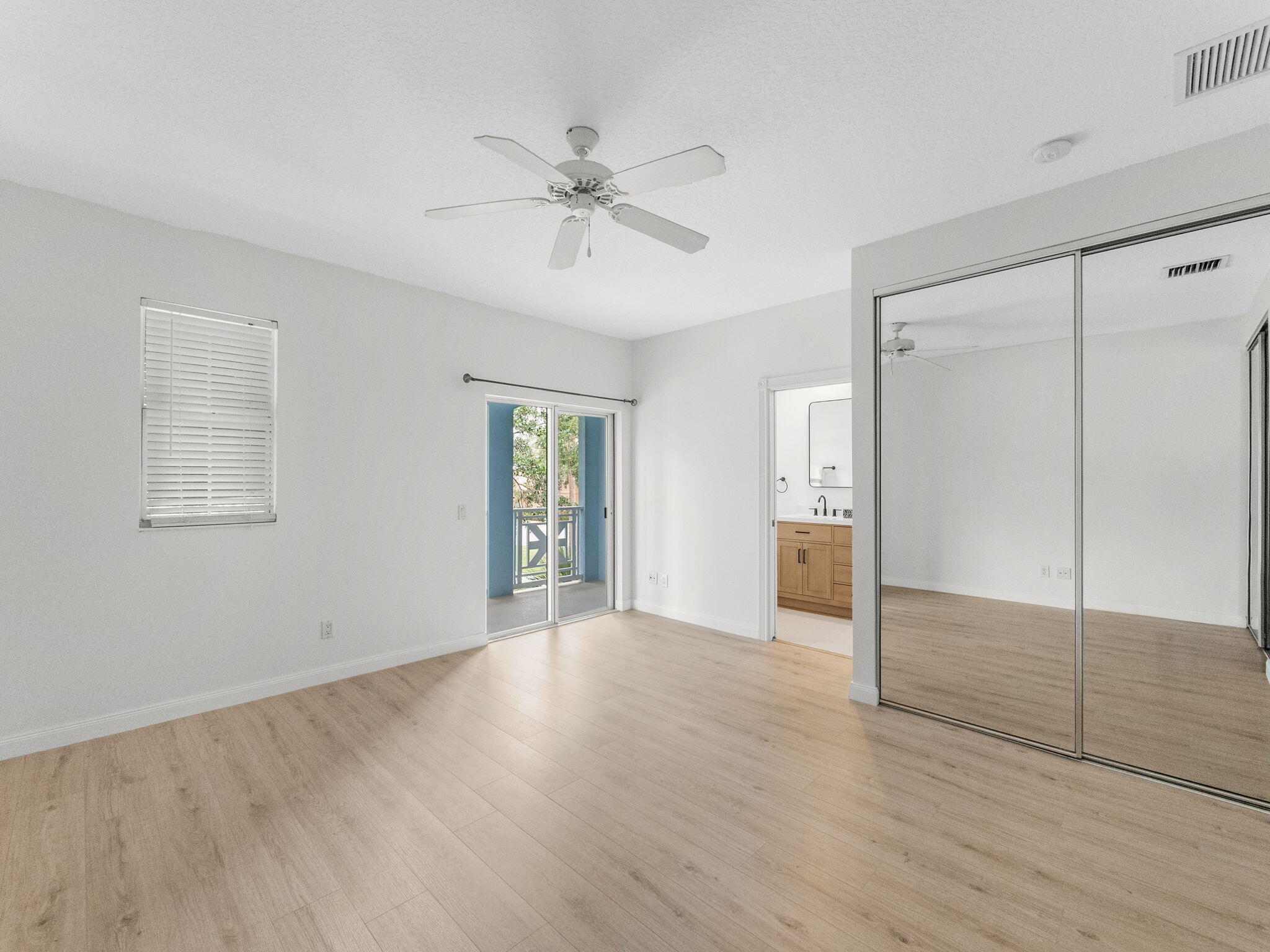 3119 East Community Drive Jupiter, FL 33458 - Photo 9 of 24 a view of an empty room with wooden floor and a window