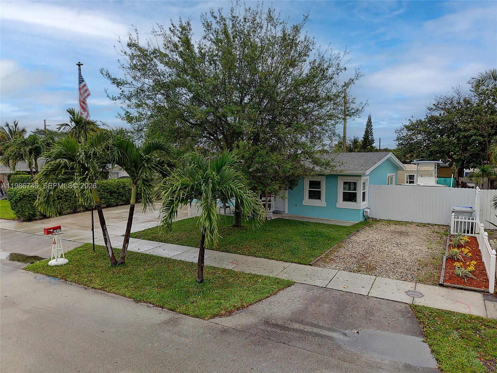 2810 Northeast 11th Terrace Pompano Beach, FL 33064 - Photo 25 of 33 a front view of a house with a yard and tree s