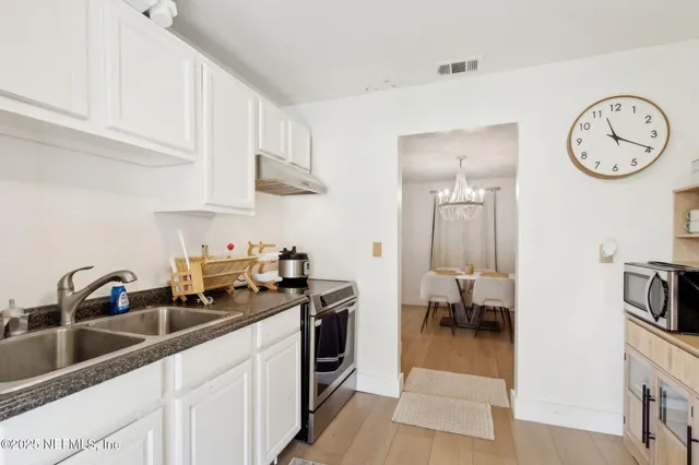 a kitchen with a sink a stove and cabinets
