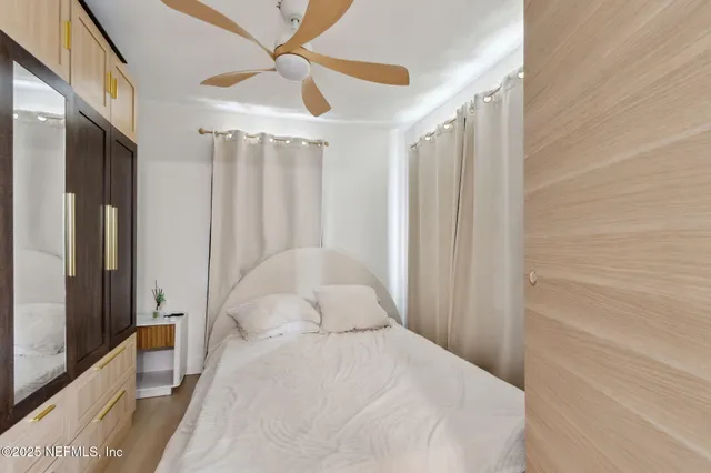 a bedroom with a large bed and a chandelier