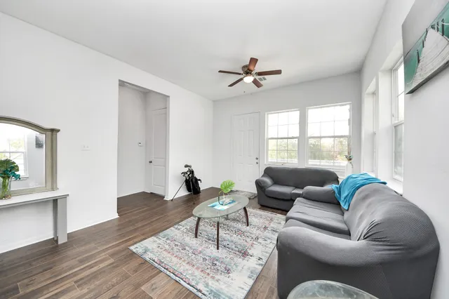 a living room with furniture a wooden floor and a window