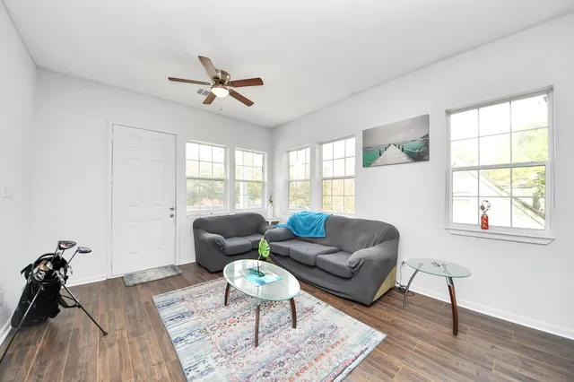 a kitchen with stainless steel appliances a stove a sink dishwasher white cabinets and wooden floor