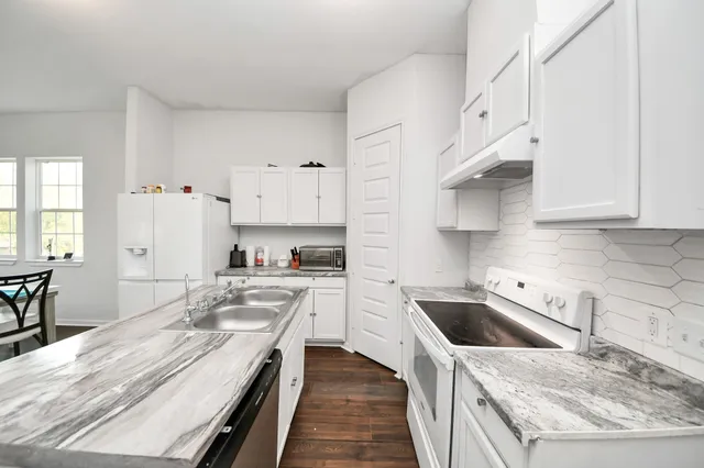 a kitchen with white cabinets and white appliances