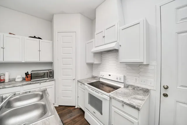 a view of a kitchen with sink and cabinets