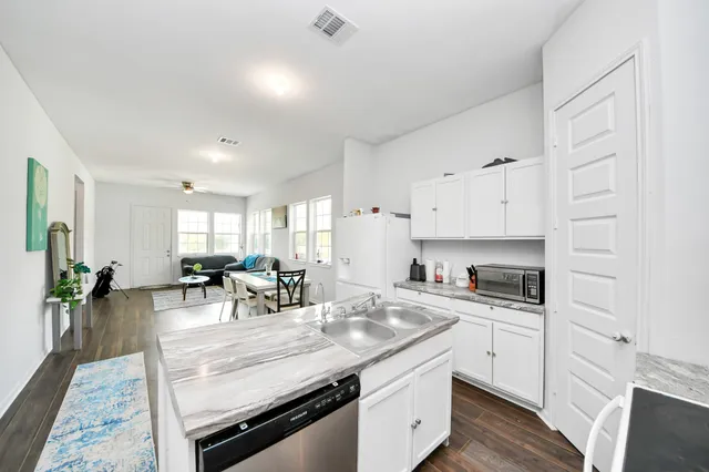 a kitchen with white cabinets and white stove