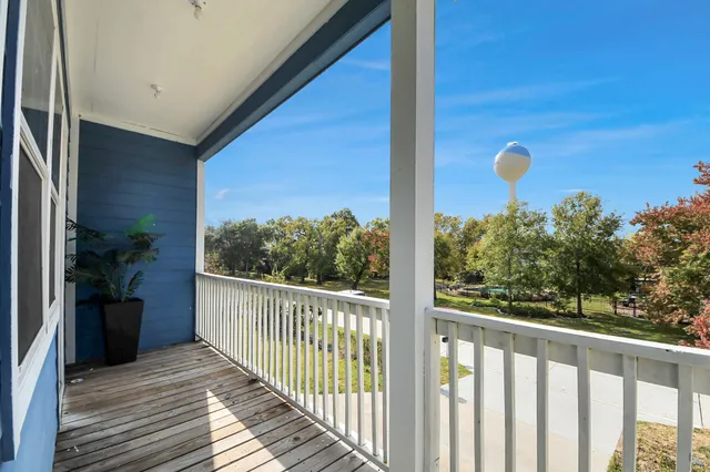 a view of a balcony with wooden floor and fence