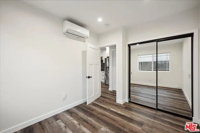 a view of a hallway with wooden floor and closet