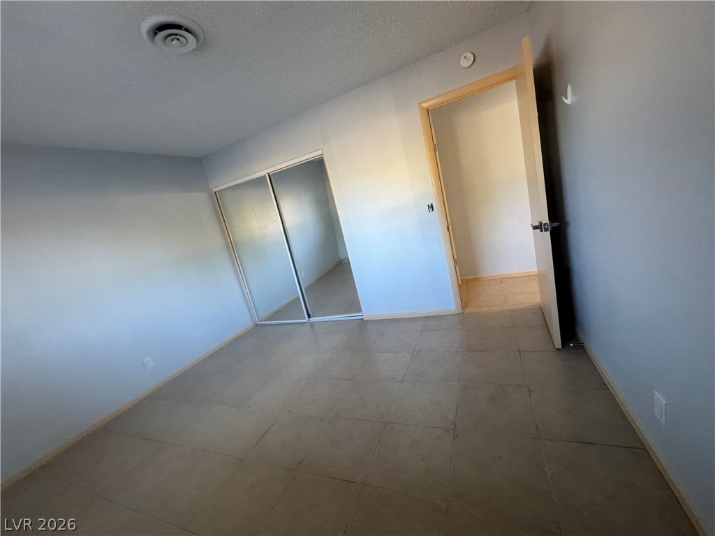 4420 Del Monte Avenue, Unit RENTAL Las Vegas, NV 89102 - Photo 17 of 20 A well-maintained bedroom features tiled flooring and mirrored closet doors.