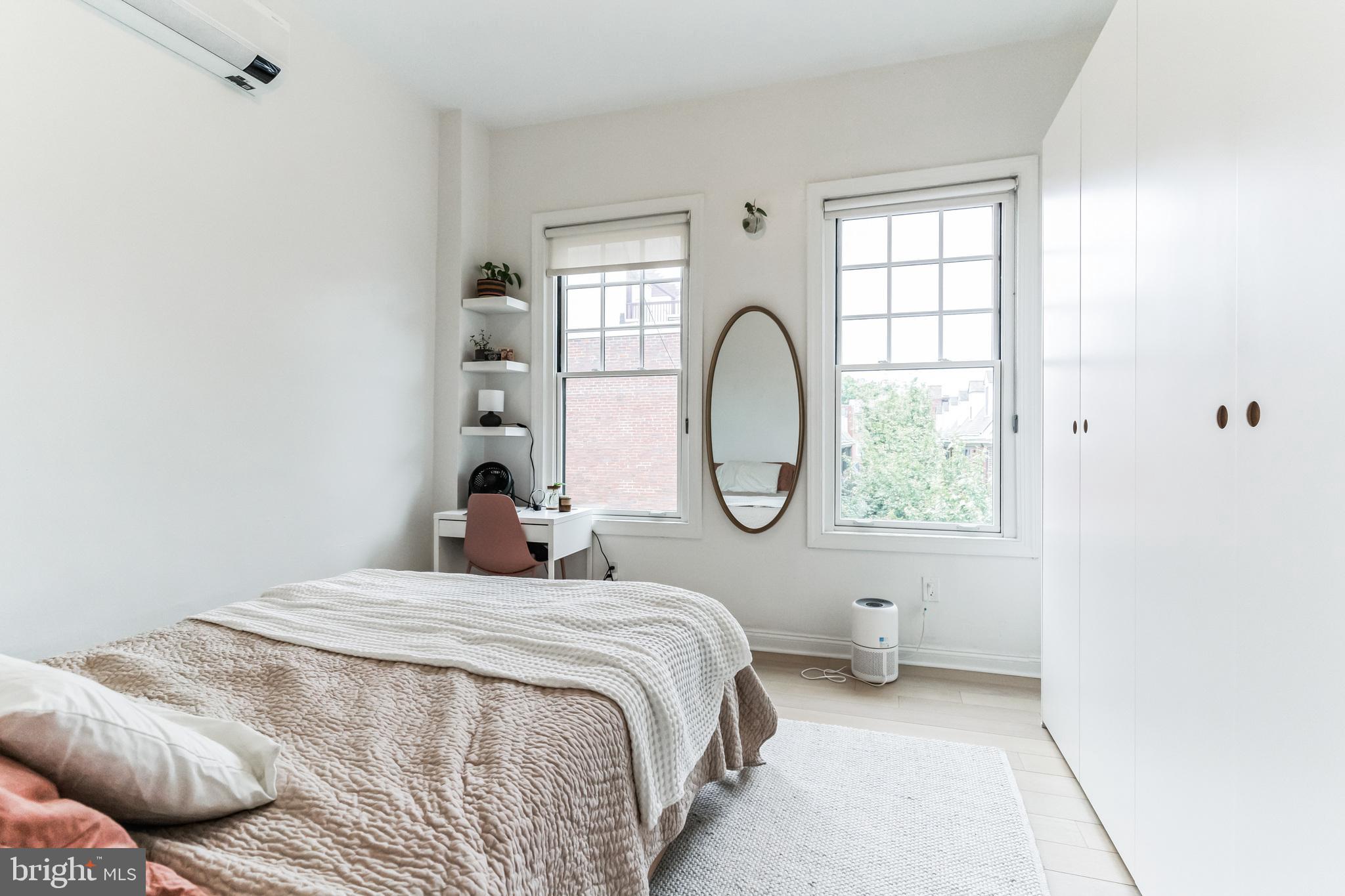 1108 Pine Street, Unit 3F Philadelphia, PA 19107 - Photo 7 of 8 a bedroom with a bed a mirror and a window