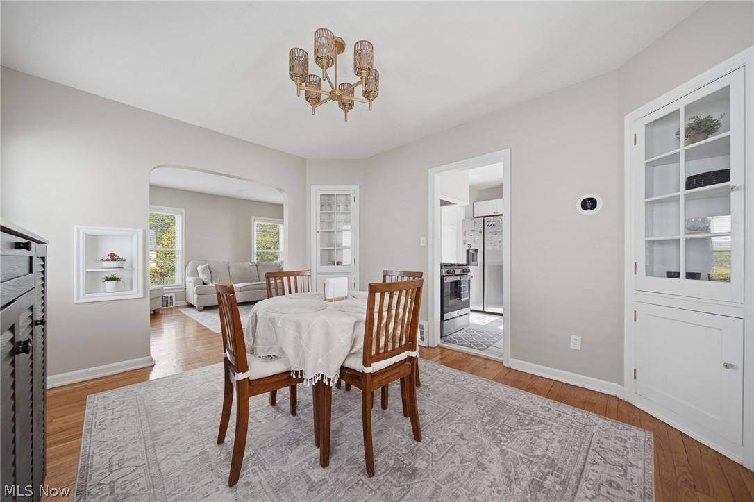 2231 Brockway Road University Heights, OH 44118 - Photo 10 of 46 Dining area with wood-finish flooring, an ornate brass-finish chandelier, and a built-in display cabinet with glass-paneled doors