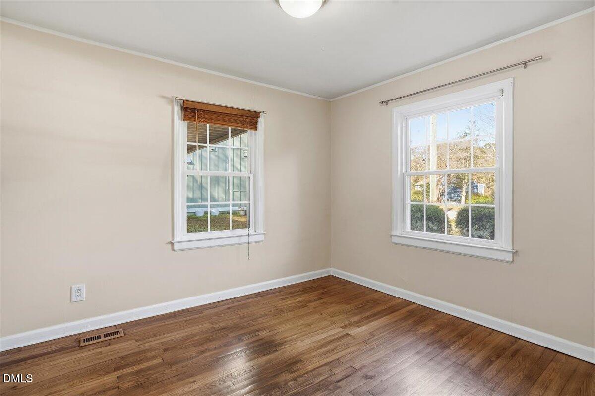 2106 Tudor Place Raleigh, NC 27610 - Photo 13 of 16 a view of an empty room with wooden floor and a window