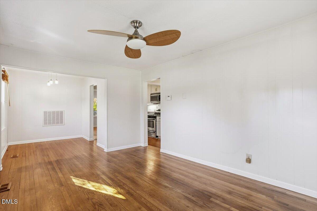 2106 Tudor Place Raleigh, NC 27610 - Photo 2 of 16 an empty room with wooden floor closet and windows
