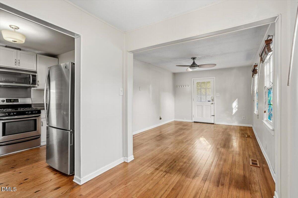 2106 Tudor Place Raleigh, NC 27610 - Photo 4 of 16 a view of a kitchen with wooden floor electronic appliances and cabinets