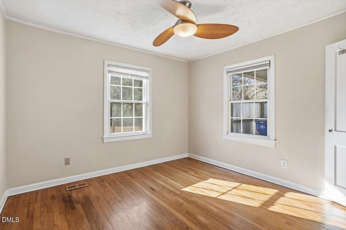 2106 Tudor Place Raleigh, NC 27610 - Photo 10 of 16 a view of an empty room with window and wooden floor