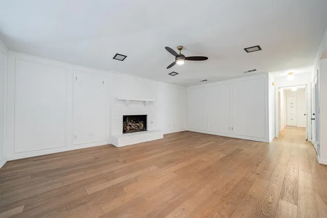 a view of empty room with wooden floor and fireplace