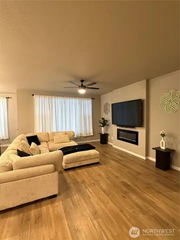 a view of a dining room with furniture wooden floor kitchen view and a chandelier