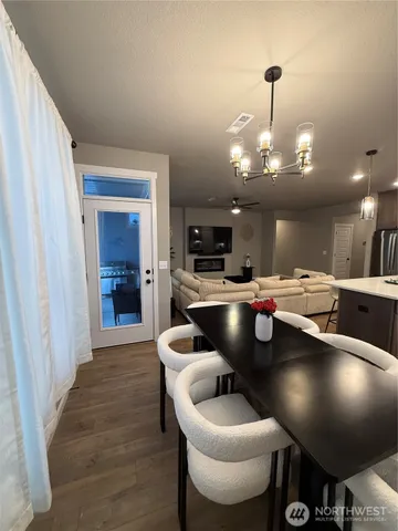 a kitchen with stainless steel appliances granite countertop a refrigerator a stove and a sink with wooden floor