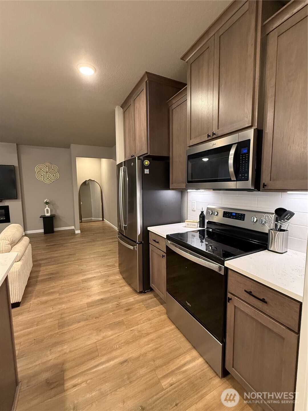 7013 South Hyton Street Cheney, WA 99004 - Photo 21 of 27 a kitchen with stainless steel appliances granite countertop a refrigerator a stove and a sink with wooden floor