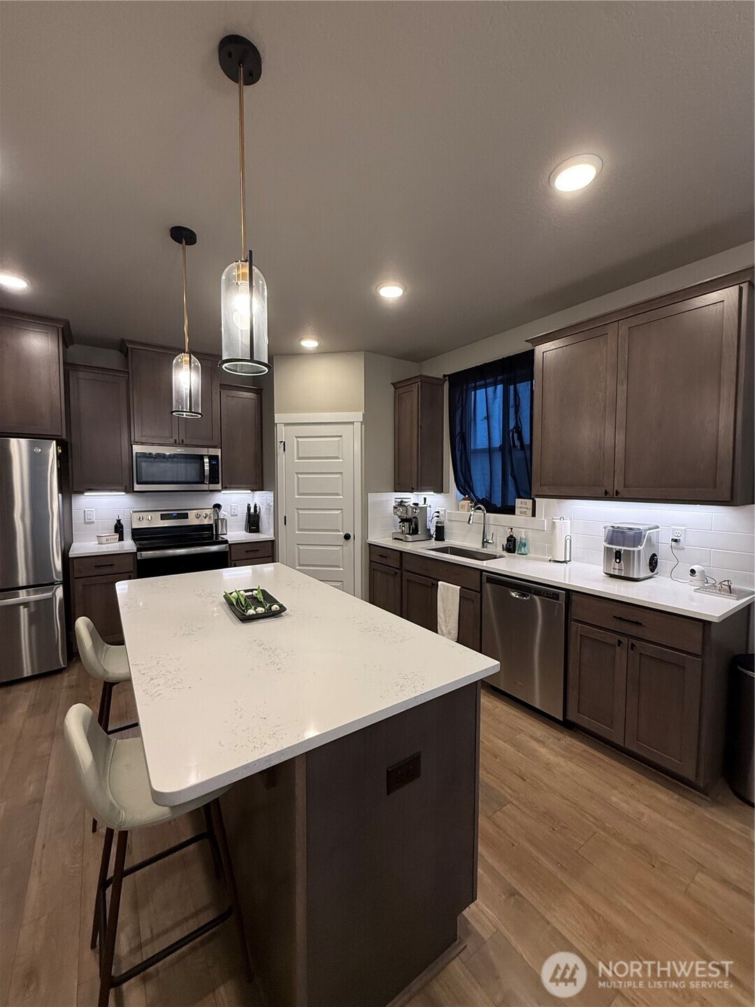 7013 South Hyton Street Cheney, WA 99004 - Photo 24 of 27 a kitchen with stainless steel appliances a sink a stove a refrigerator white cabinets and wooden floor