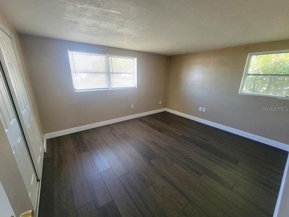 7922 Kelpie Drive Port Richey, FL 34668 - Photo 15 of 24 a view of an empty room with wooden floor and a window