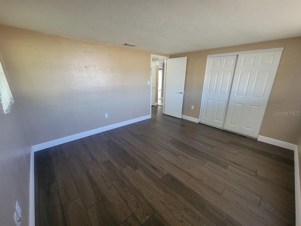 7922 Kelpie Drive Port Richey, FL 34668 - Photo 16 of 24 a view of an empty room with wooden floor