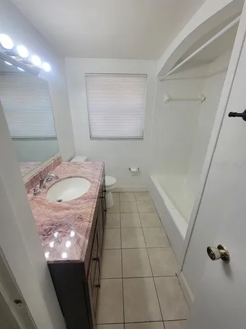 a bathroom with a granite countertop sink a mirror and shower