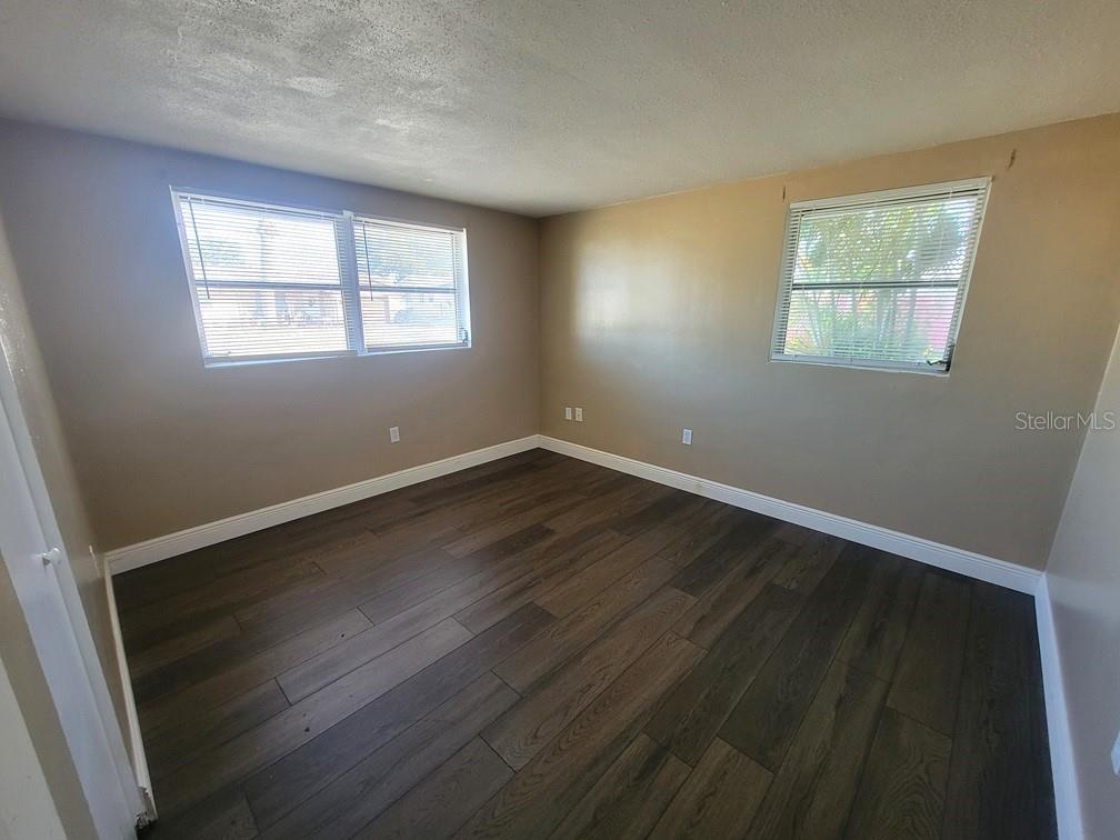 7922 Kelpie Drive Port Richey, FL 34668 - Photo 20 of 24 a view of an empty room with wooden floor and a window