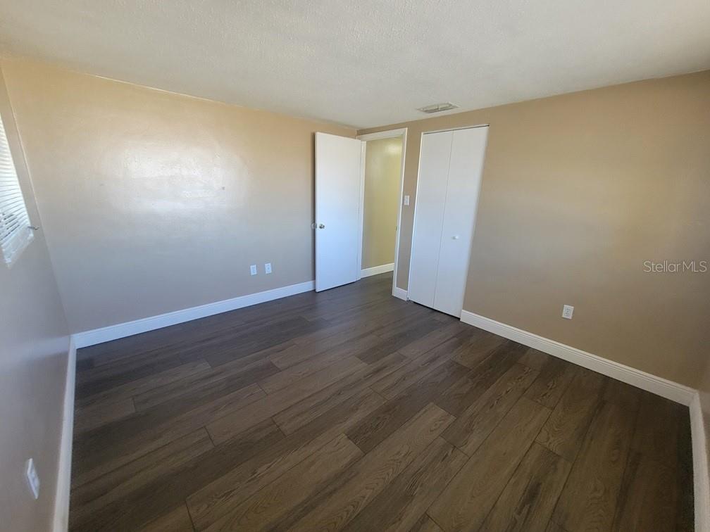 7922 Kelpie Drive Port Richey, FL 34668 - Photo 21 of 24 a view of an empty room with wooden floor