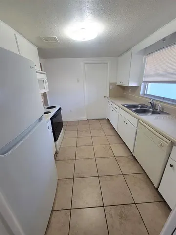 a kitchen with a sink a stove and a refrigerator
