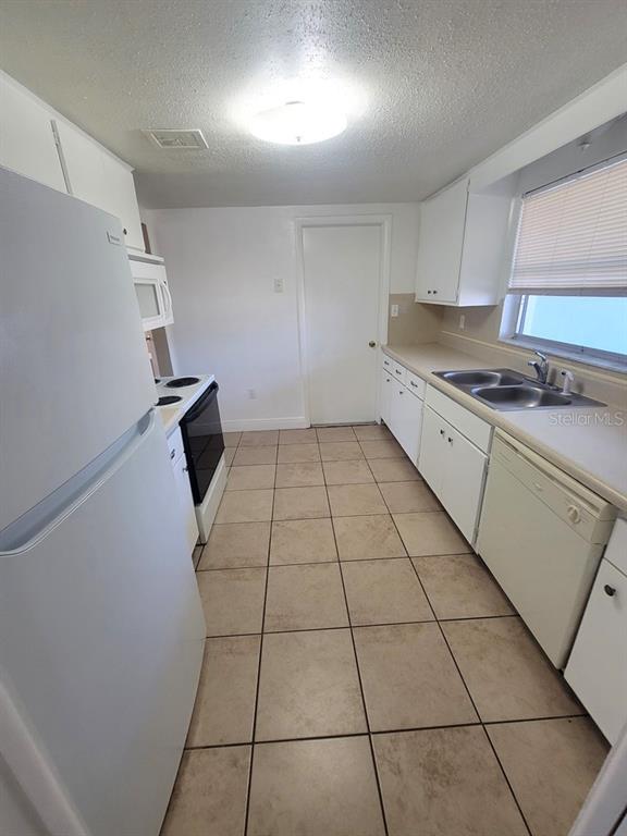 7922 Kelpie Drive Port Richey, FL 34668 - Photo 7 of 24 a kitchen with a sink a stove and a refrigerator