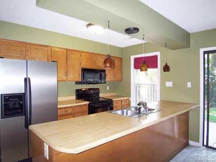 1505 Edgeside Court Raleigh, NC 27609 - Photo 5 of 10 a kitchen with stainless steel appliances kitchen island granite countertop a sink and refrigerator