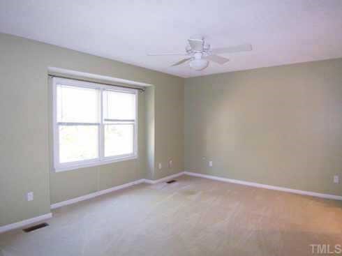 1505 Edgeside Court Raleigh, NC 27609 - Photo 7 of 10 en empty room with windows and chandelier fan