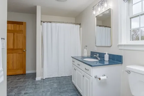a bathroom with a sink a toilet and a mirror