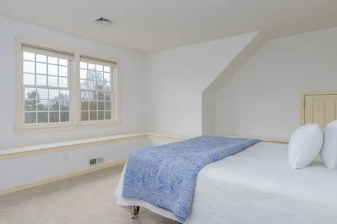 a bedroom with a bed and a large window