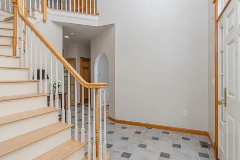 a view of staircase with lots of frames on wall and a window