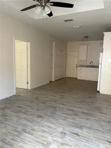a view of an empty room with a kitchen
