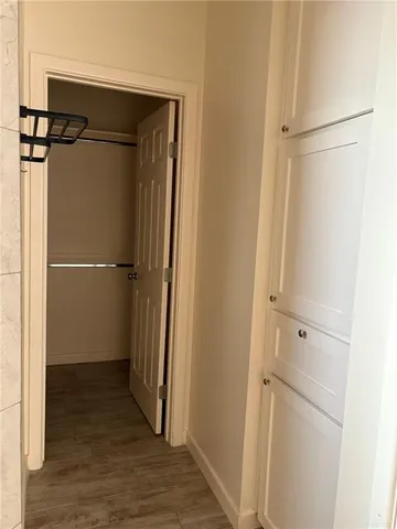 a view of walk in closet with wooden floor