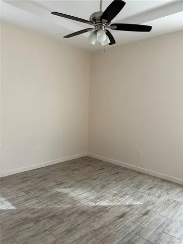 a view of a room with wooden floor and a ceiling fan