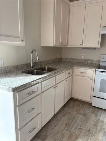 a kitchen with granite countertop white cabinets and white appliances
