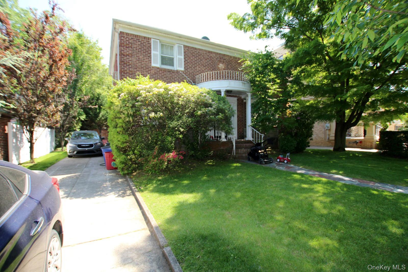 187-14 Aberdeen Road Queens, NY 11432 - Photo 2 of 20 Brick facade home featuring a portico entry with balustrade details