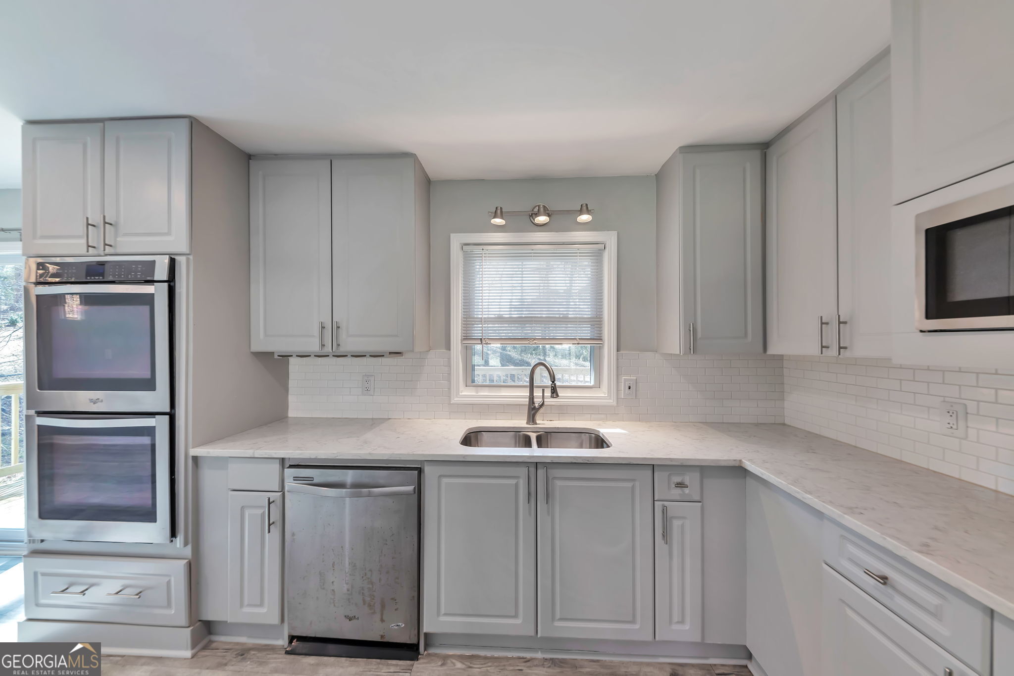 2764 Veltre Place Southwest Atlanta, GA 30311 - Photo 12 of 30 a kitchen with stainless steel appliances granite countertop a sink a stove and cabinets