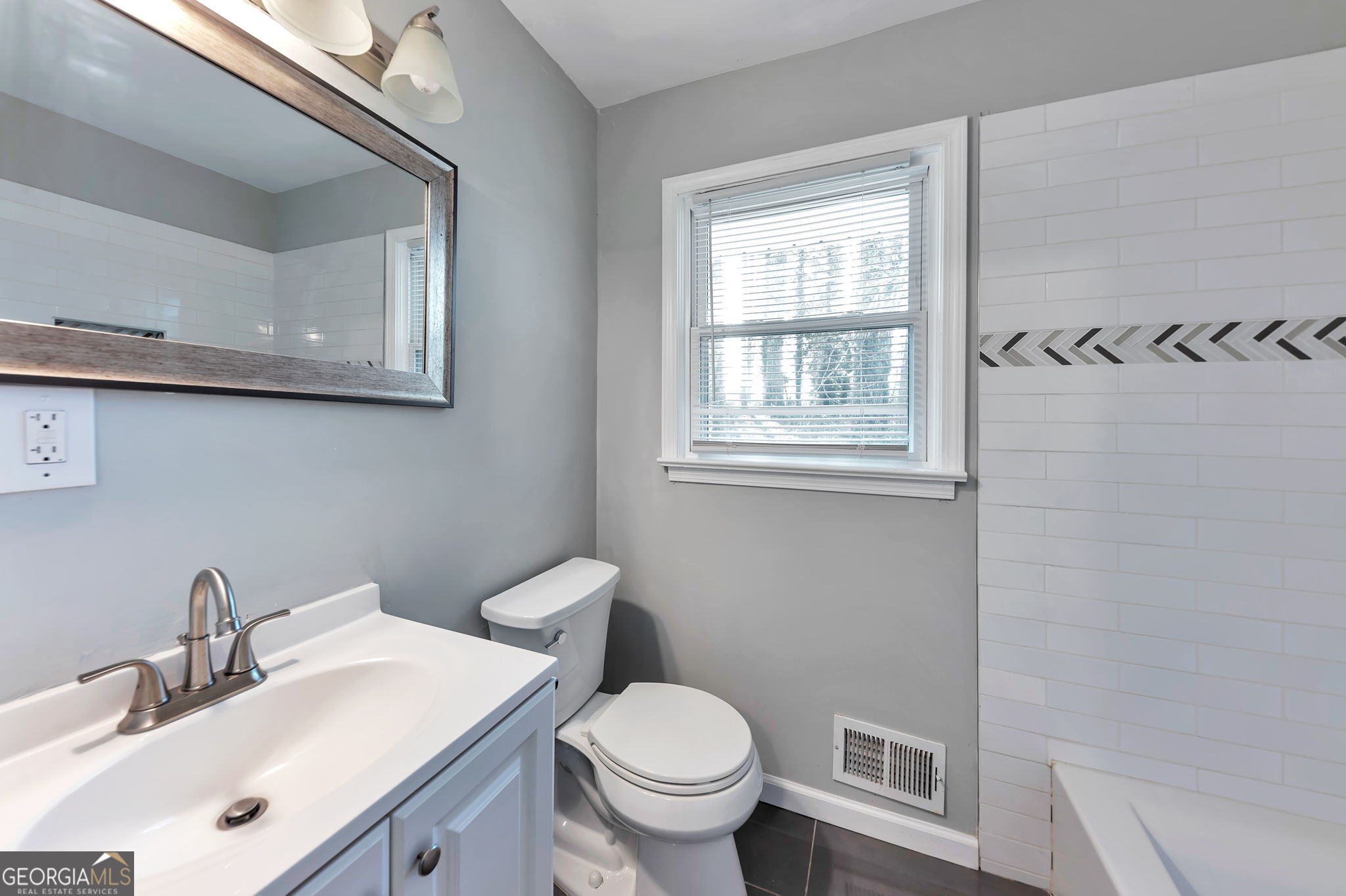 2764 Veltre Place Southwest Atlanta, GA 30311 - Photo 18 of 30 a bathroom with a toilet a sink a mirror and a window