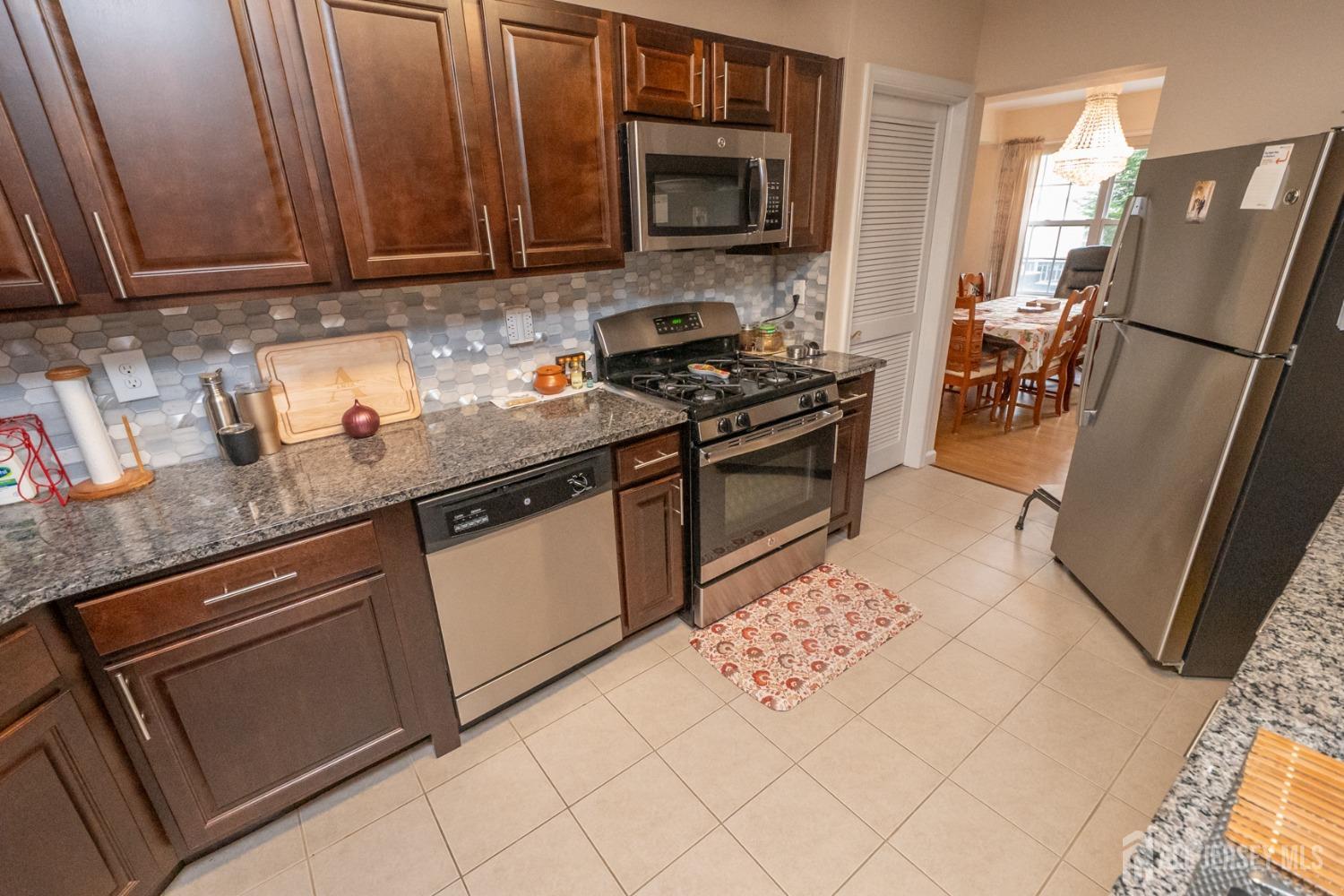 1405 Plymouth Road North Brunswick, NJ 08902 - Photo 12 of 32 a kitchen with stainless steel appliances granite countertop a stove a sink and a refrigerator