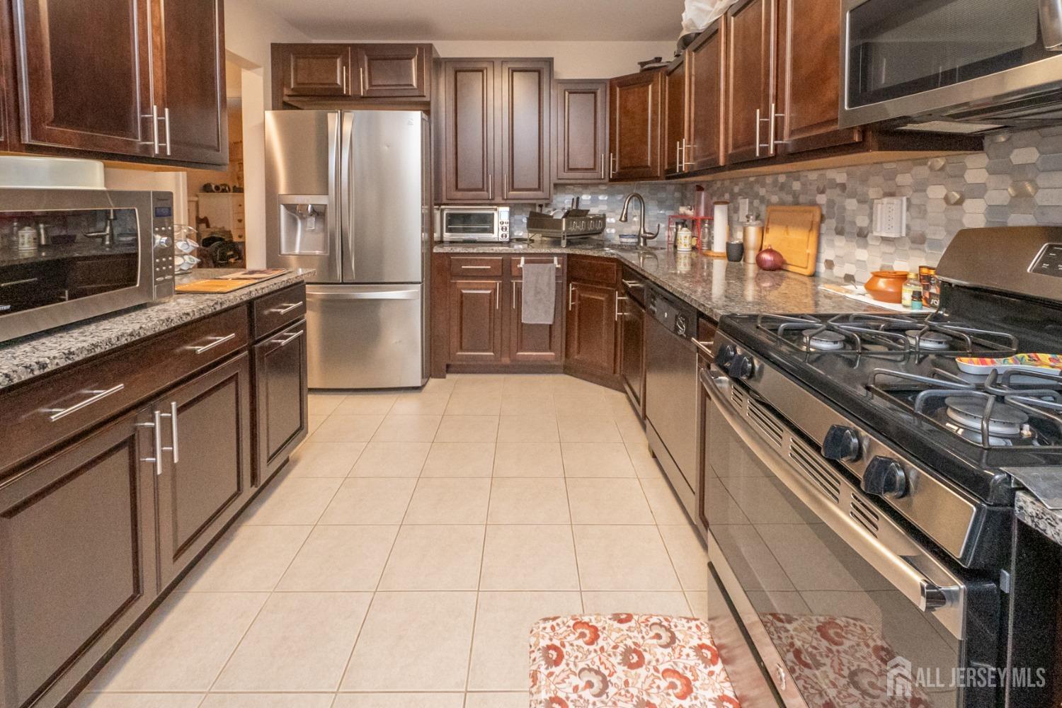 1405 Plymouth Road North Brunswick, NJ 08902 - Photo 15 of 32 a kitchen with stainless steel appliances granite countertop a stove a sink dishwasher and a refrigerator