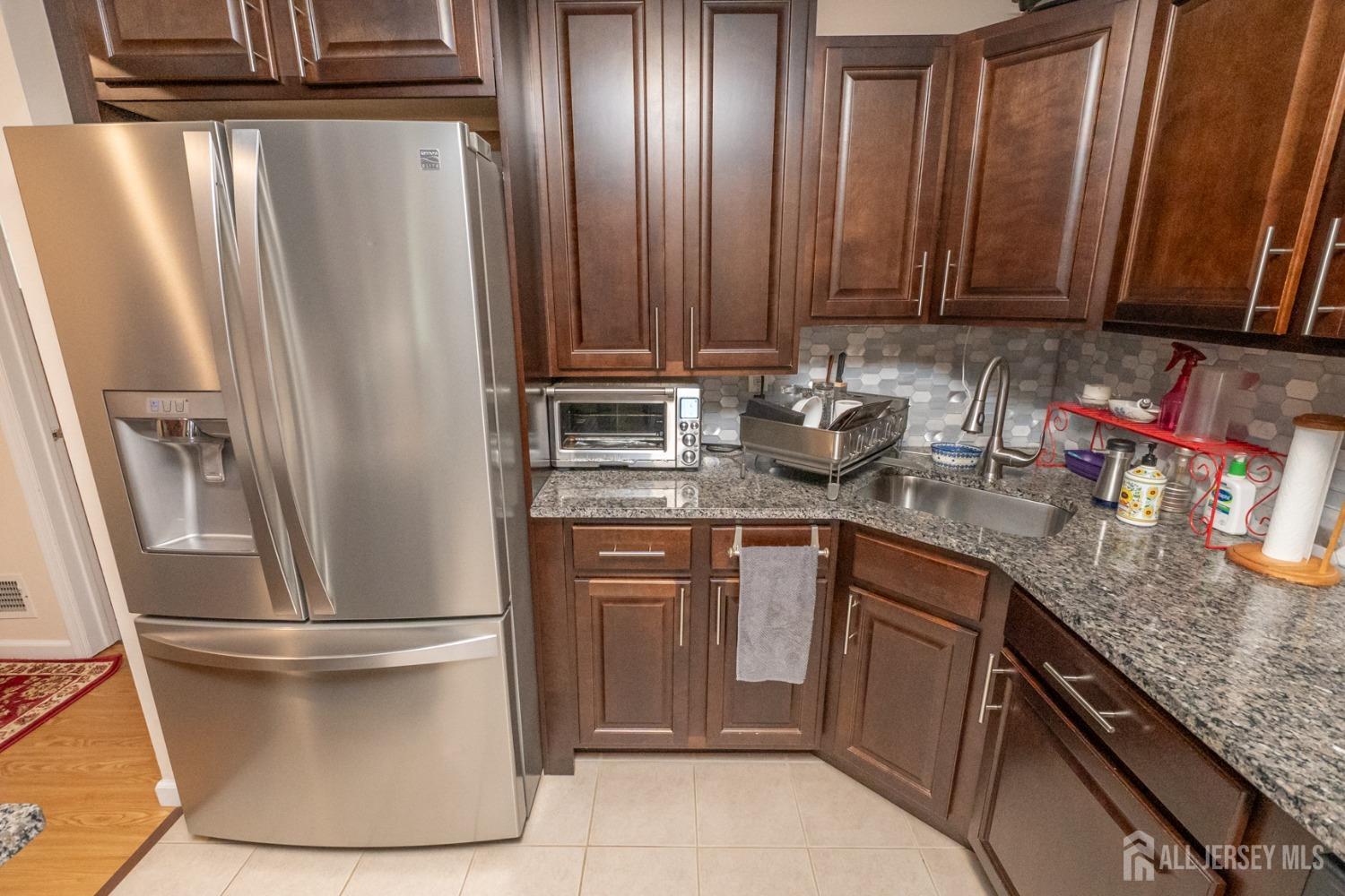 1405 Plymouth Road North Brunswick, NJ 08902 - Photo 10 of 32 a kitchen with sink a refrigerator and cabinets