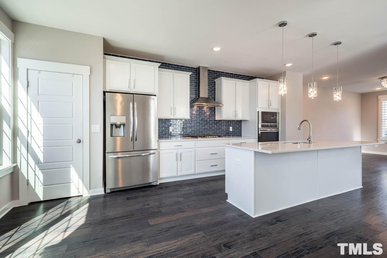 444 Rally Point Place Wake Forest, NC 27587 - Photo 15 of 38 a large kitchen with stainless steel appliances a refrigerator and a stove top oven