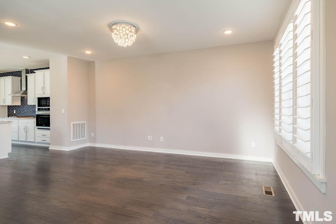 444 Rally Point Place Wake Forest, NC 27587 - Photo 10 of 38 an empty room with wooden floor and windows
