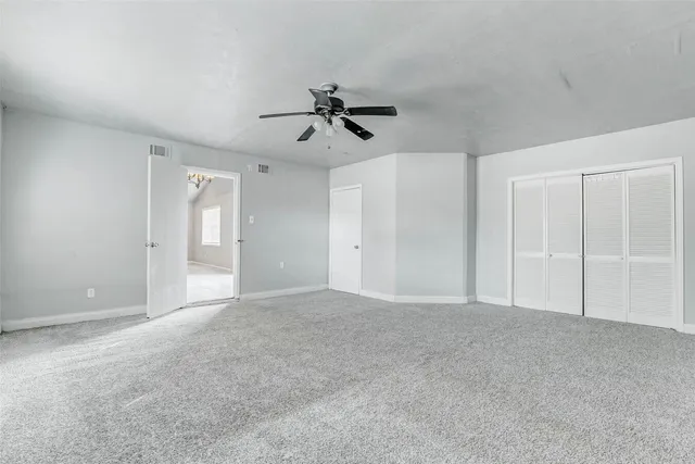 a view of empty room with ceiling fan