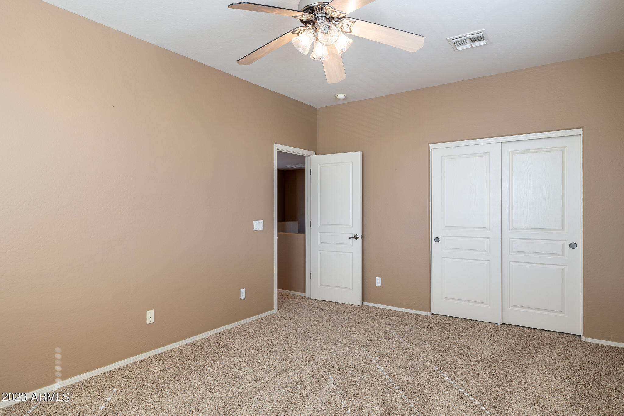 3344 West Montello Road Phoenix, AZ 85086 - Photo 30 of 38 an empty room with chandelier fan and closet area